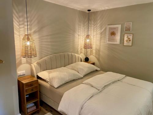 a bed in a bedroom with two lights on it at Neue Hafenliebe in Neustadt in Holstein