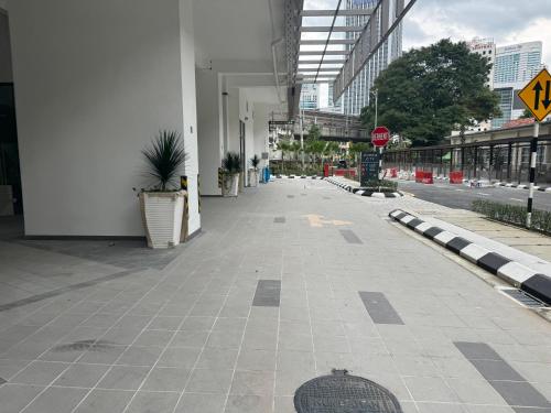 een lege stoep in een stad met een stopbord bij The Riveria City Brickfield by GoMain in Kuala Lumpur