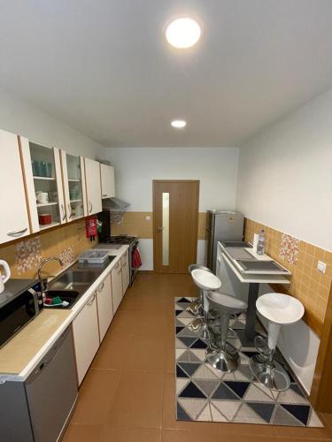 a kitchen with a sink and stools in it at Luxury 2bed flat with free parking in Bratislava