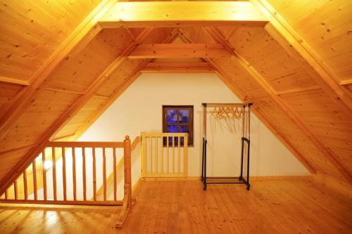 an attic with a wooden ceiling and a staircase at Dům na Krásné ve Středohoří in Vlastislav