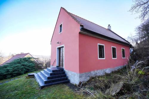a red house with stairs on the side of it at Dům na Krásné ve Středohoří in Vlastislav