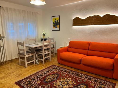 a living room with an orange couch and a table at White House in Sauze dʼOulx