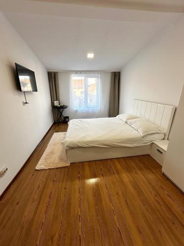 a bedroom with a bed and a wooden floor at Stone Residence in Braşov