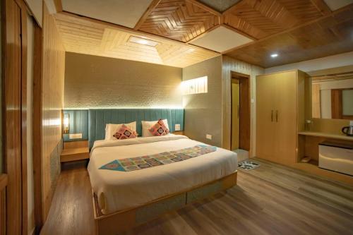 een slaapkamer met een groot bed in een kamer bij Aman The Lake Side Hotel in Nainital