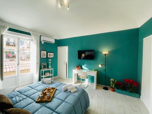 a blue bedroom with a bed and a desk at A Casa di Clu - your private SPA in Palermo