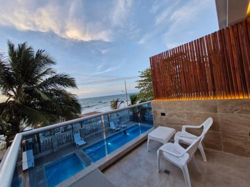 a balcony with a view of a swimming pool and the ocean at Camino Palmero Coveñas in Coveñas