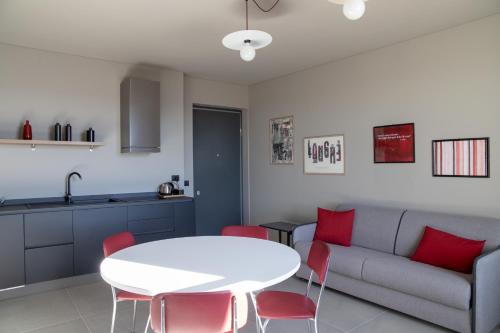 a kitchen and a living room with a table and a couch at Casa La Vedetta in Barbaresco