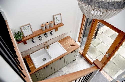 eine Küche mit einem Waschbecken und einem Fenster in der Unterkunft Woodman's Cottage in Temple Ewell