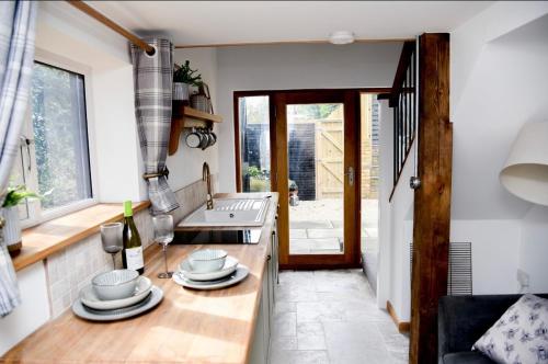 a kitchen with a counter with plates on it at Woodman's Cottage in Temple Ewell