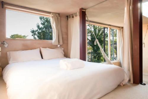 uma grande cama branca num quarto com uma janela em Stunning studio loft in Brixton, London em Londres
