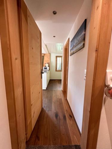 a hallway with wooden floors and a kitchen in a house at Chalet Solaria 2 bedrooms with mountain and garden view in Zweisimmen