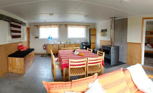 a dining room and kitchen with a table and chairs at CABAÑA ESTANCIA LAZO in Torres del Paine