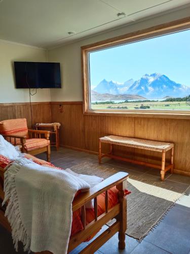 a room with a large window with a view of mountains at CABAÑA ESTANCIA LAZO in Torres del Paine