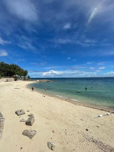 a beach with people swimming in the water at The Beach Suite at The Mactan Newtown in Lapu Lapu City