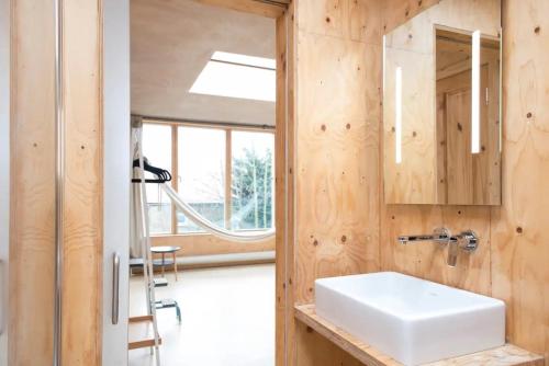 La salle de bains est pourvue d'un lavabo blanc et d'un miroir. dans l'établissement Stunning studio loft in Brixton, London, à Londres