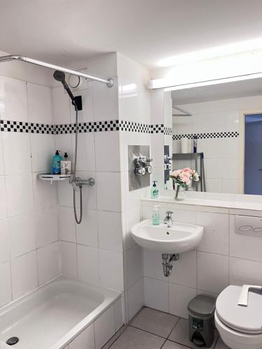 ein weißes Bad mit einem Waschbecken und einem WC in der Unterkunft Ferienwohnungen in Köln2201 in Köln