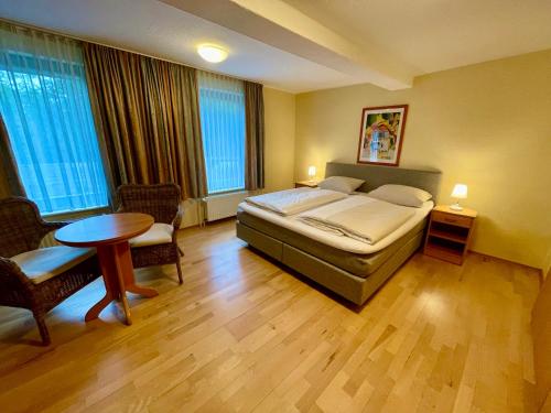 Schlafzimmer mit einem Bett, einem Tisch und Stühlen in der Unterkunft Hotel Restaurant Steinkrug in Wennigsen