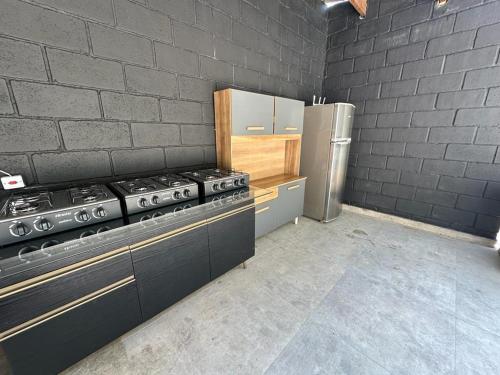 a kitchen with a stove and a refrigerator at Reserva Athenas - Clube de campo in Jacareí