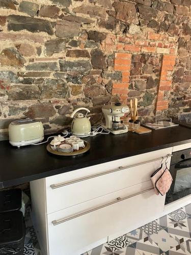 - une cuisine avec un comptoir et un mur en pierre dans l'établissement La Maison Cahour, à Redon