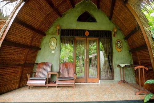 two chairs sitting on the outside of a house at Green Travelodge Bukit Lawang in Bukit Lawang