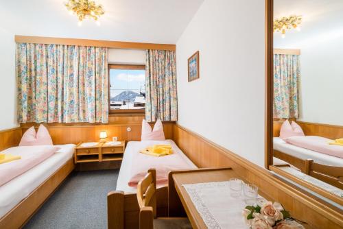 a hotel room with two beds and a mirror at Pension Rainhof in Kitzbühel