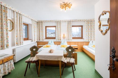 a dining room with two tables and two beds at Pension Rainhof in Kitzbühel