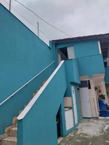 a blue building with a staircase next to it at Casa em Ubatuba perto da praia in Ubatuba