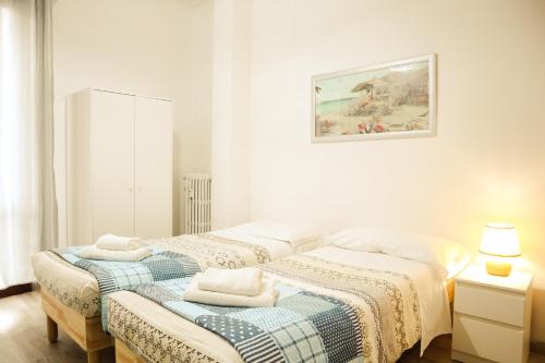 佛羅倫斯的住宿－Florence Rooms Novella，白色客房内的两张床和毛巾