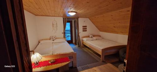 Habitación con 2 camas en una habitación de madera en Gyopár Vendégház en Satu Mare