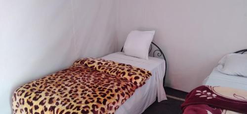 a room with a leopard print bed in a corner at Chegaga Regency Camp in El Gouera