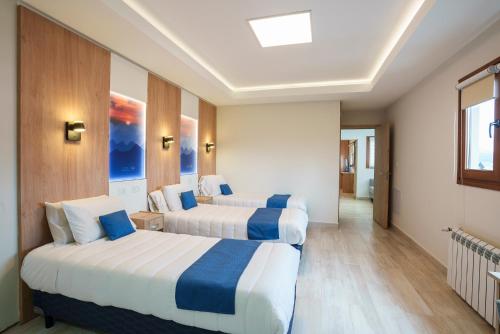 a hotel room with two beds and a hallway at Cabañas Tierra Mistica in Ushuaia