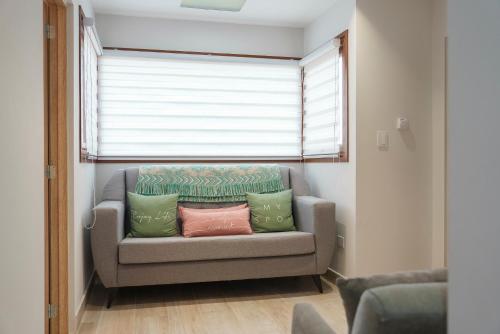 a couch with pillows in a room with a window at Cabañas Tierra Mistica in Ushuaia