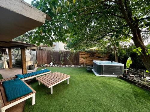 une arrière-cour avec une table de pique-nique et un bain à remous dans l'établissement Villa l'Albizia accès privé rivière, à Porto-Vecchio