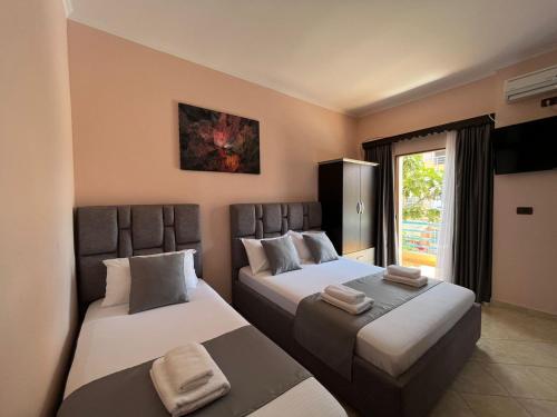 a hotel room with two beds and a window at Vila Laura in Ksamil