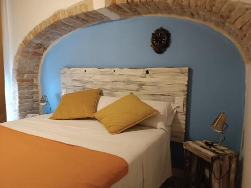 1 dormitorio con 1 cama con pared azul en Petra apartments -Old City with terrace and barbecue-, en Tarragona