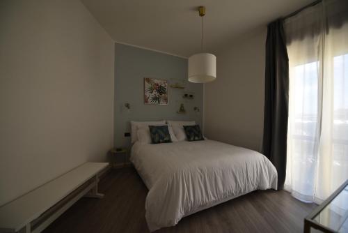 een witte slaapkamer met een bed en een raam bij Élite Suite Home in Termoli