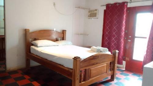 a bedroom with a wooden bed and a window at Quinta Tisseaux in Casares