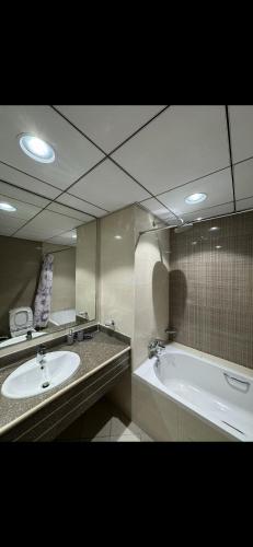 a bathroom with a tub and a sink and a mirror at Dream Beach View in Ajman 