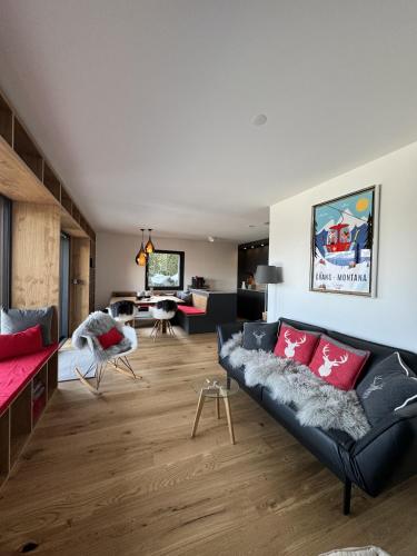 a living room with a black couch and red pillows at Mirador Lodge - Crans Montana - Swiss Alps in Crans-Montana