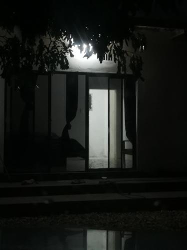 a silhouette of a person sitting in a window at night at Northside beach lodge in Vilanculos