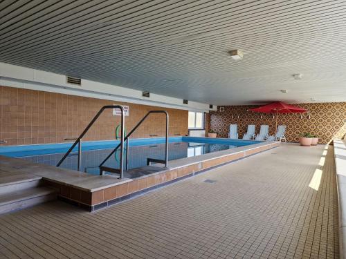a large swimming pool in a building with a pool at FeWo Inselblick mit Schwimmbad - Horumersiel in Horumersiel
