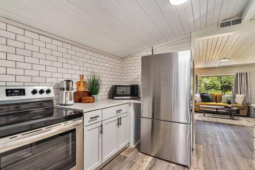 a kitchen with a stainless steel refrigerator and a living room at Beautiful Southhaven Shores in South Haven