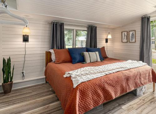 a bedroom with a bed with blue and orange pillows at Beautiful Southhaven Shores in South Haven