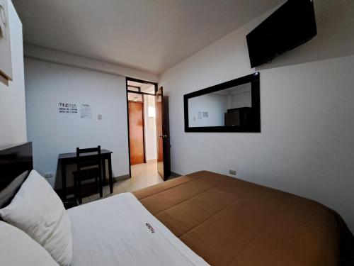 a bedroom with a bed with a mirror and a desk at TintayaHotel in Chachapoyas