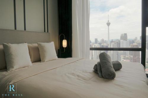 - une chambre avec un lit avec un animal rembourré dans l'établissement The Ress - The Axon Bukit Bintang Residence, à Kuala Lumpur
