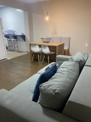 a living room with a couch and a table at Guarapari Apolo Confort in Guarapari