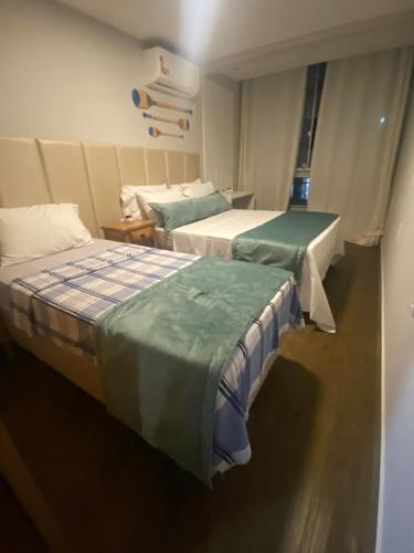 two beds in a hospital room withacers at Guarapari Apolo Confort in Guarapari