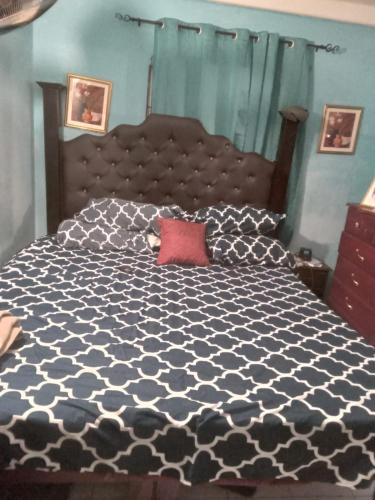 - une chambre avec un lit noir et blanc et un oreiller rouge dans l'établissement Sewell's Inn Jamaica, à Chedwin Park