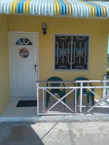 a table and two chairs outside of a building at Sewell's Inn Jamaica in Chedwin Park