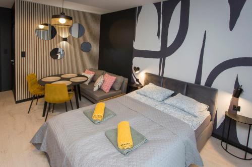 een slaapkamer met een bed, een tafel en stoelen bij Urban Jungle apartament Delta in Białystok